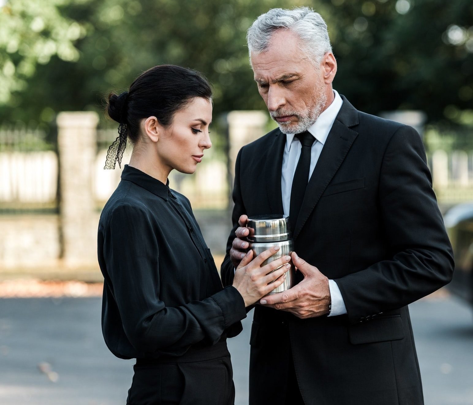 senior man and attractive woman holding mortuary urn e1636771781202.jpg