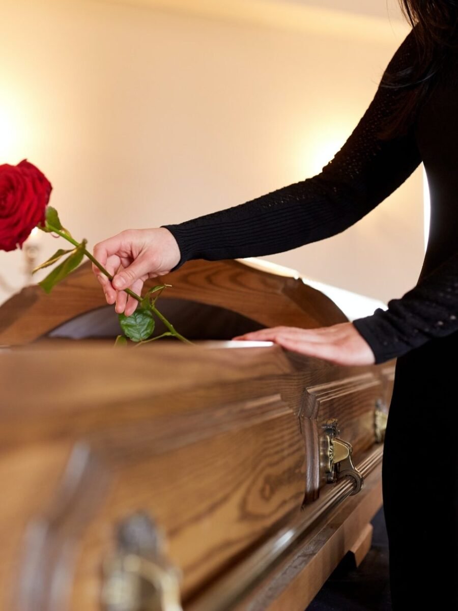 woman with red roses and coffin at funeral.jpg